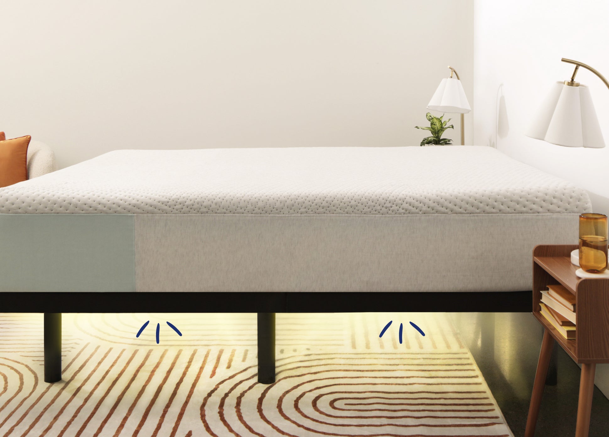 Image of a mattress on top of the Adjustable Base Max. Underneath the frame appear illustrations to indicate from where adaptive lighting emits to illuminate your path when needing to get out of bed in the middle of the night.