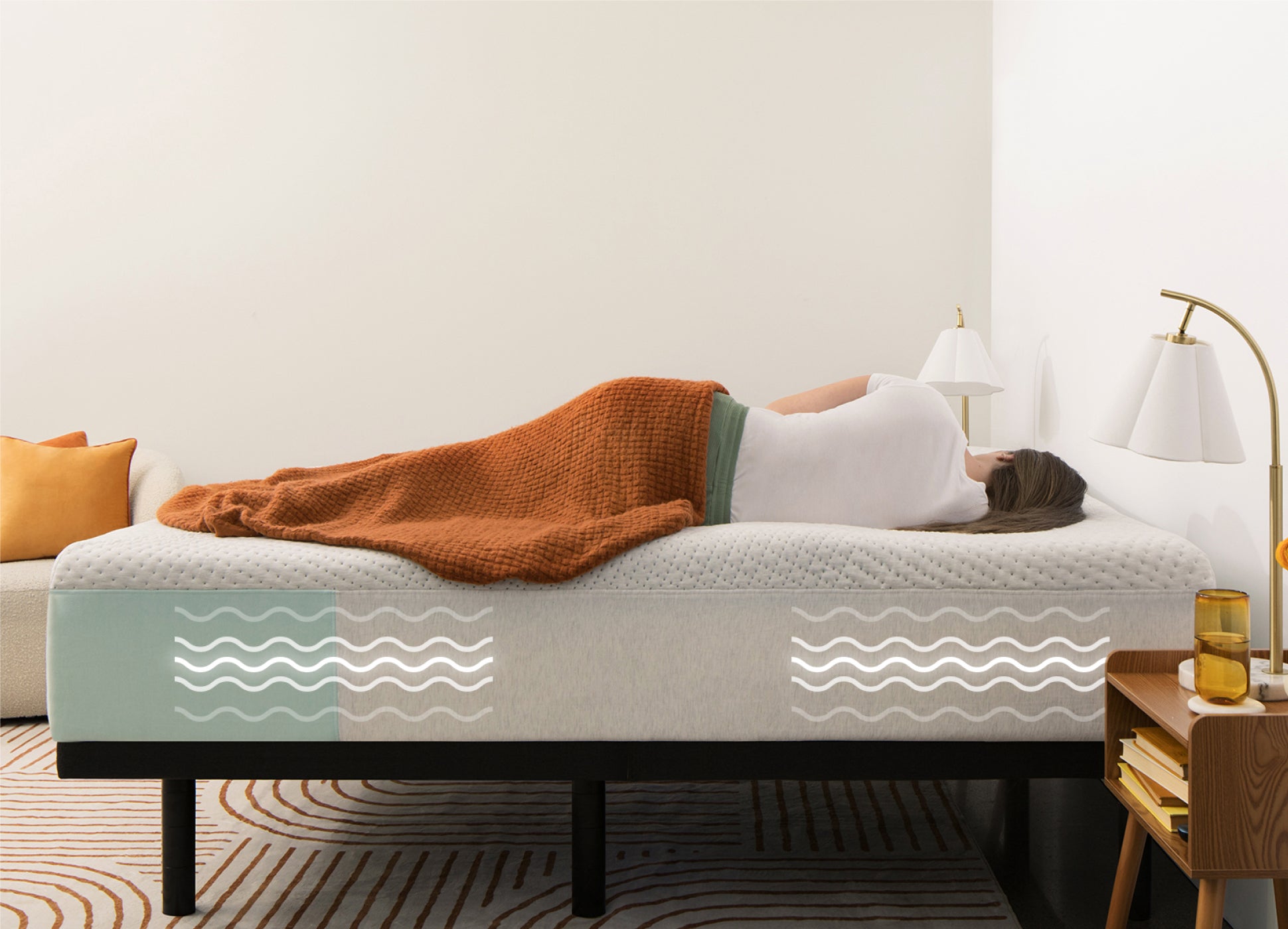 Image of a person lying on her side on the mattress. A series of wavy lines are illustration on the mattress underneath here where the 3-level massages are designed to gently lull you to rest.