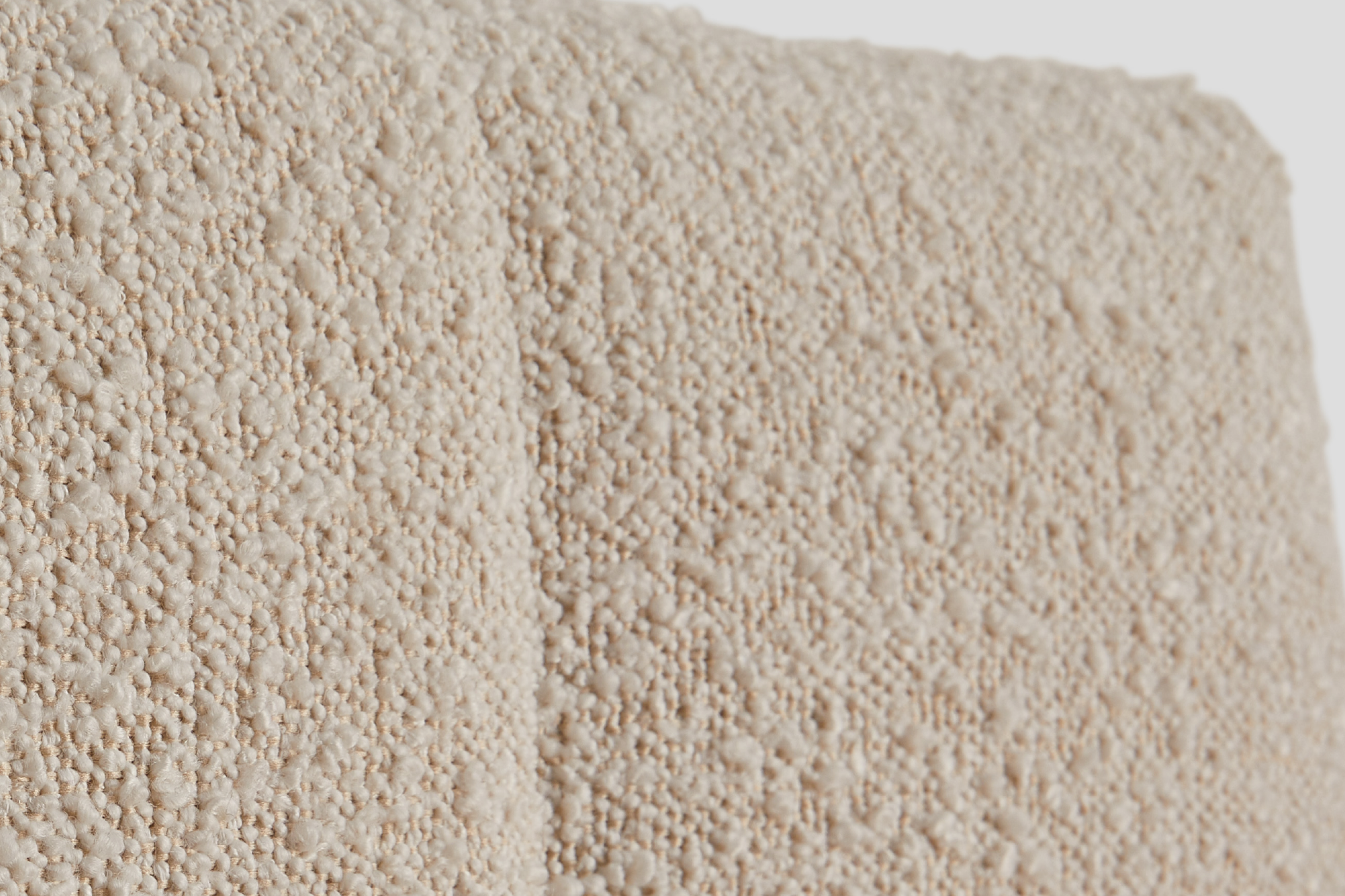 Close-up of a textured cream-colored fabric of the Bliss Attachable Headboard