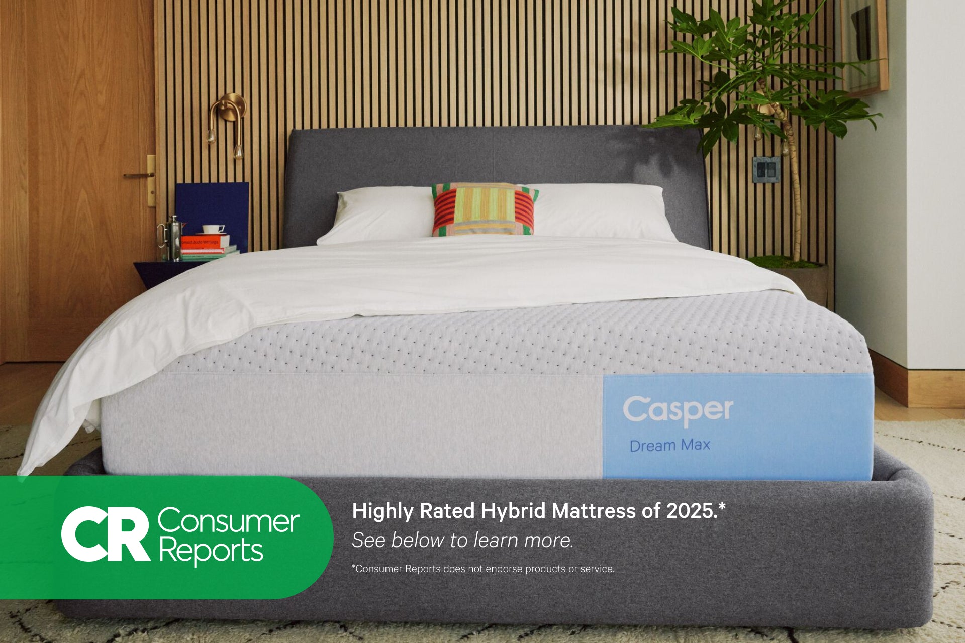 Front view of Casper's Dream Max mattress on a bed frame with pillows and a folded blanket on top. At the bottom of the image appears text that reads "Consumer Reports. Highly rated hybrid mattress of 2025.* See below to learn more. *Consumer Reports does not endorse products or service."