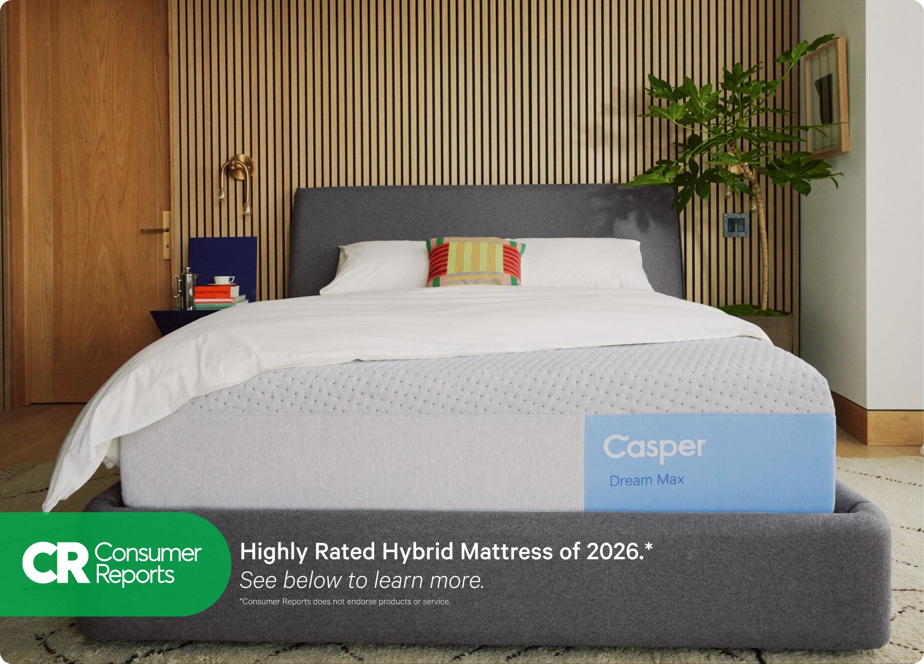 Front view of Casper's Dream Max mattress on a bed frame with pillows and a folded blanket on top. At the bottom of the image appears text that reads "Consumer Reports. Highly rated hybrid mattress of 2026.* See below to learn more. *Consumer Reports does not endorse products or service."