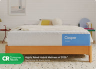 Front-view of the Casper Dream mattress on a wooden bed frame with pillows and a blanket folded on top. Beneath the image there appears a banner which says, "Consumer Reports. Highly rated hybrid mattress of 2026. See below to learn more. *Consumer Reports does not endorse products or service."