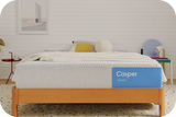 Casper's Dream mattress on a bed frame with pillows and a blanket folded on top.