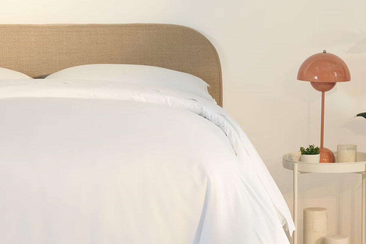 A fully made bed with a Drift Attachable Headboard, Taupe color. Close-up of right half.