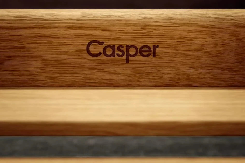 Close-up of a wooden panel of the Repose Bed Frame that has the word "Casper" engraved into it