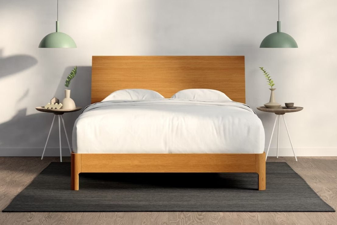 A fully made bed with a Repose Bed Frame and wooden headboard. Front View.