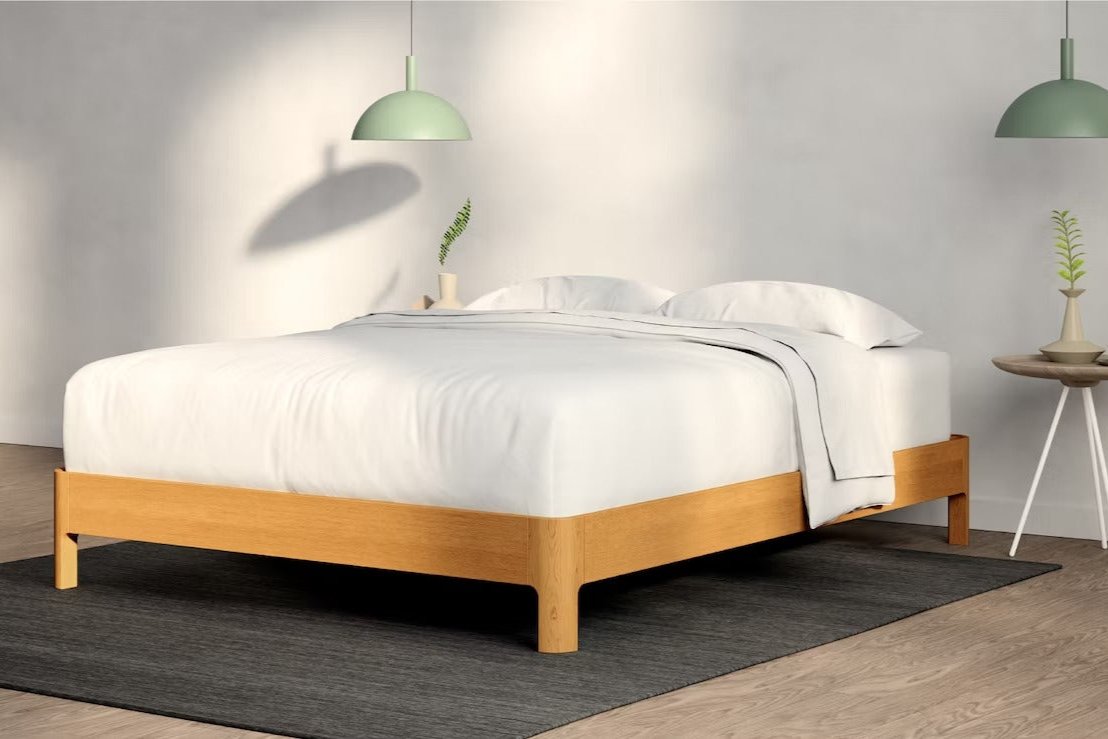 A fully made bed with a Repose Bed Frame. Corner View.
