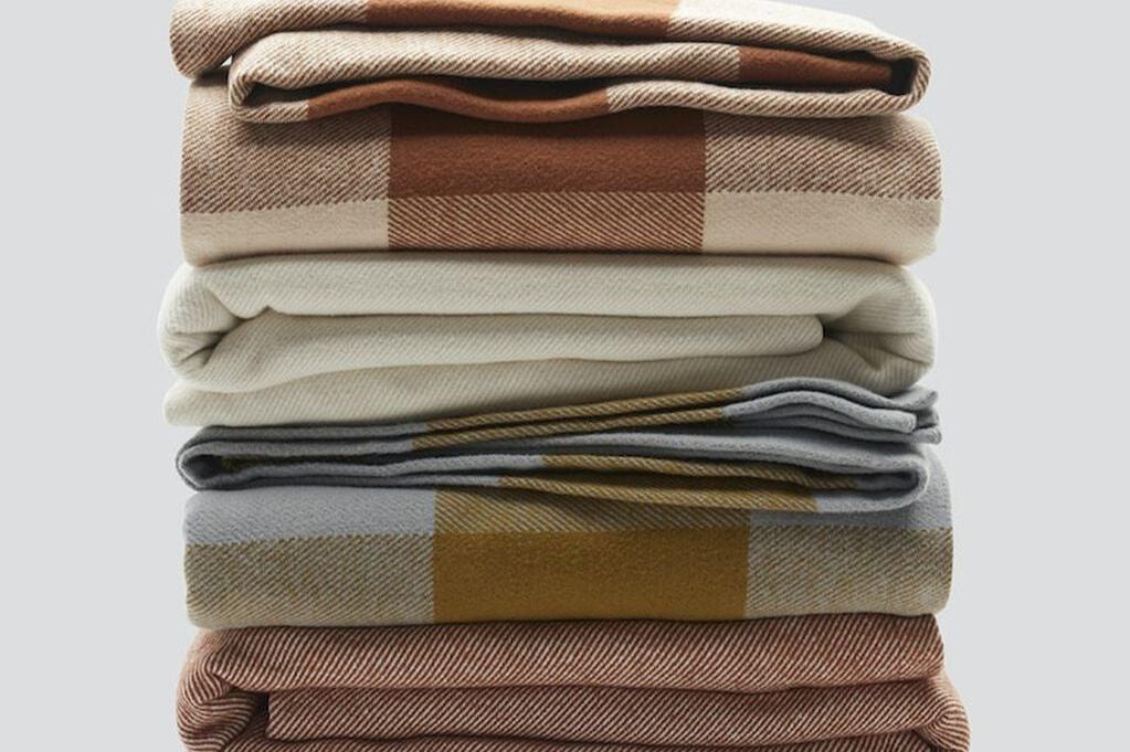 Cozy Woven Blankets, various colors, folded and stacked on top of each other