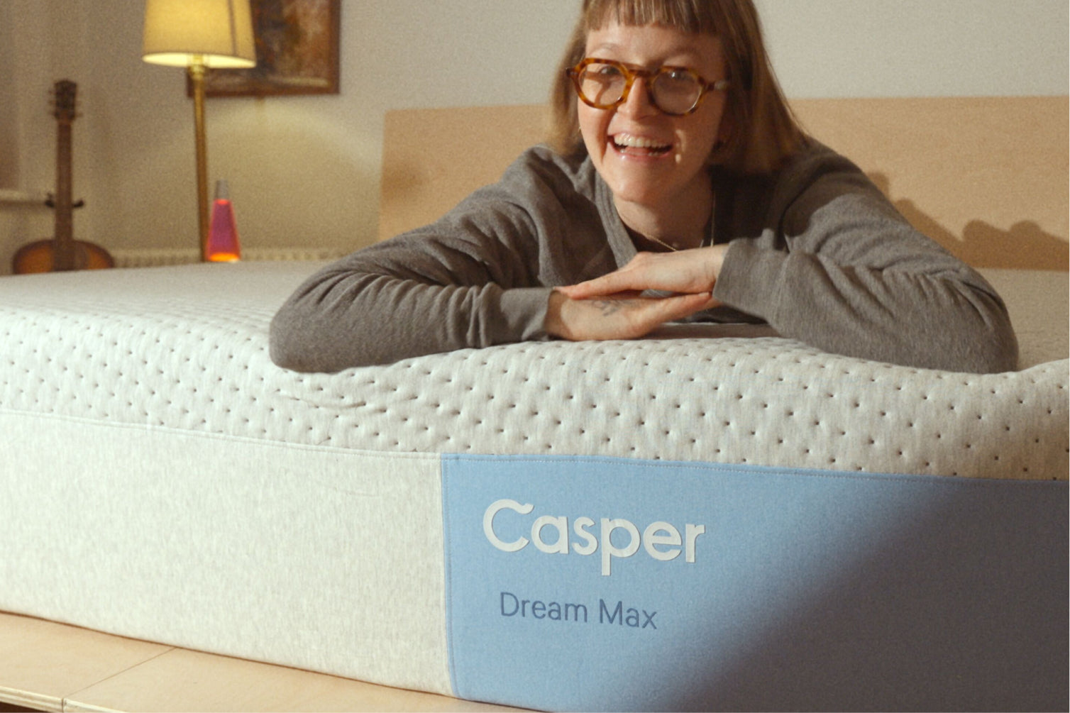 Person lying on a Casper Dream Max mattress in a bedroom setting