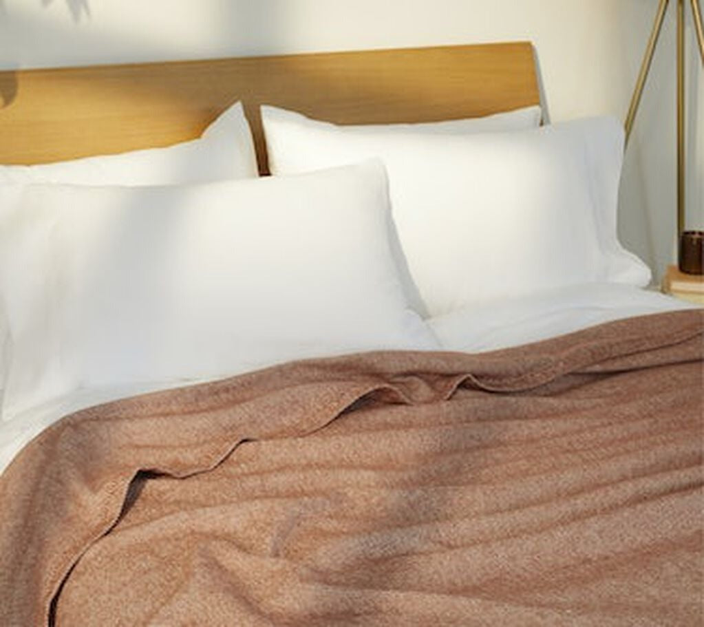 Cozy Woven Blanket, spice, on a mattress.