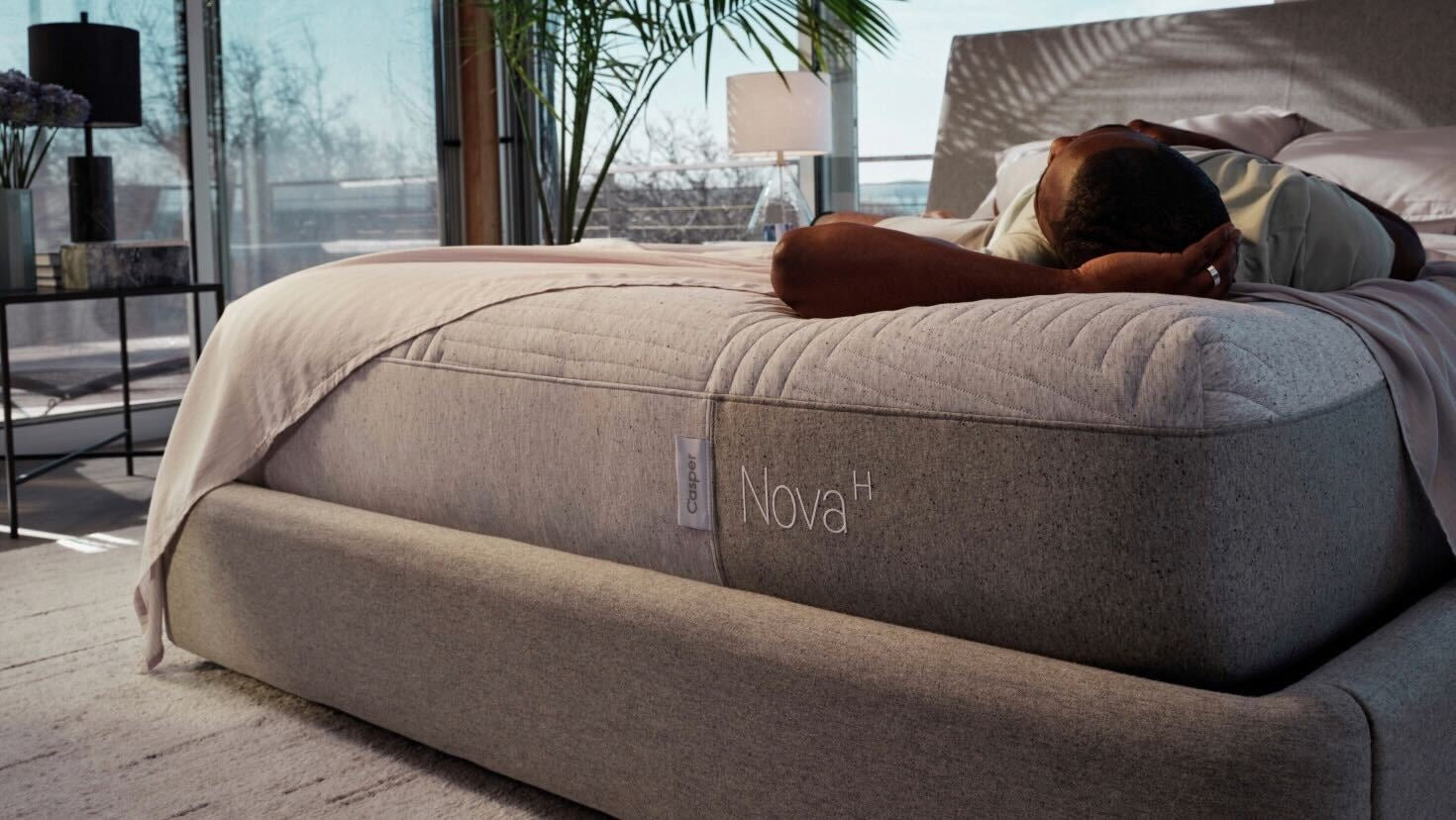 Corner image of a person lying on their back in bed. The mattress is on top of a Haven Bed Frame.