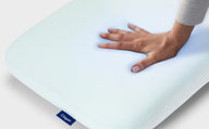 A hand feeling the Hybrid Pillow with Snow Technology.