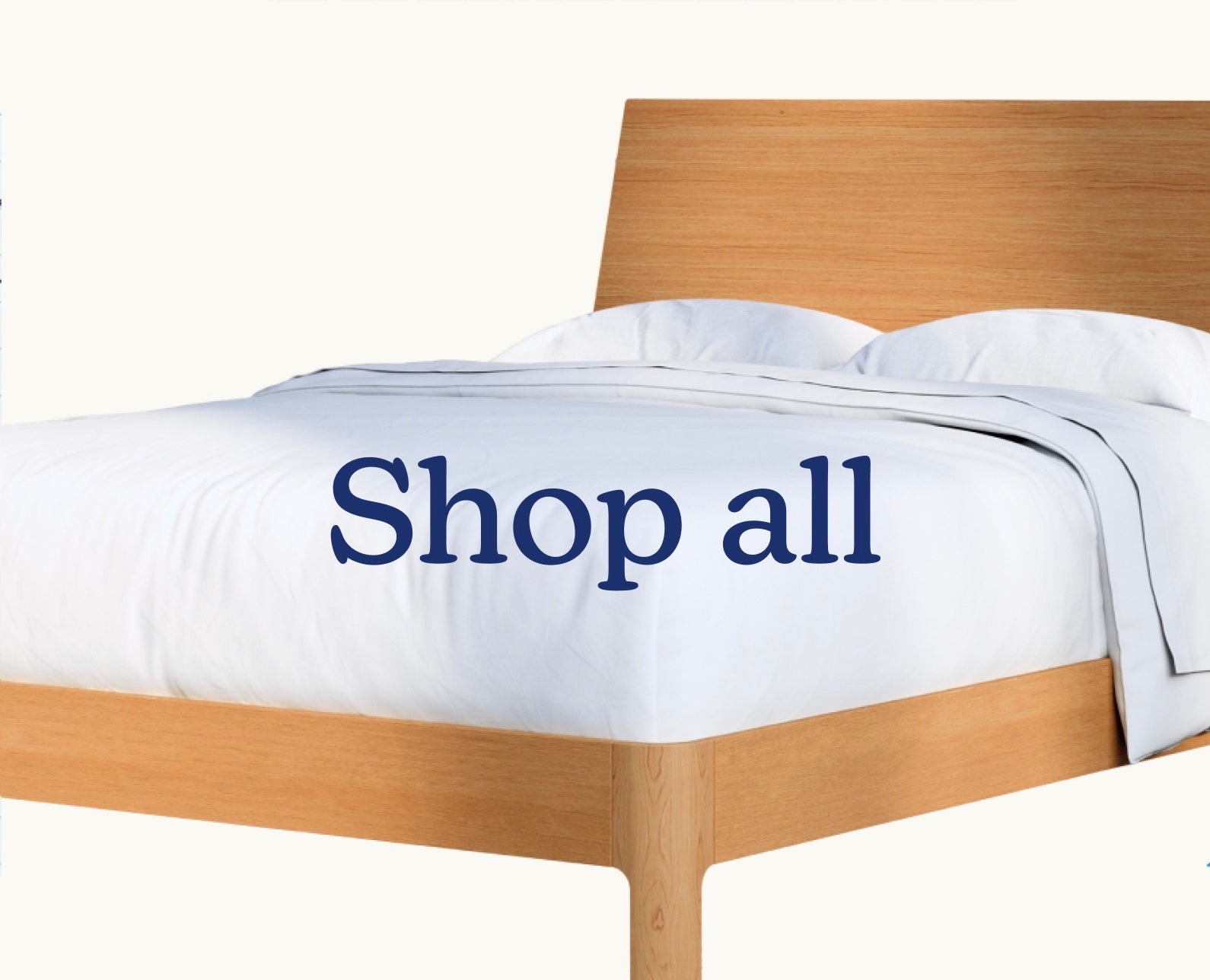 Wooden bed frame with white bedding. Text over image says "Shop All"