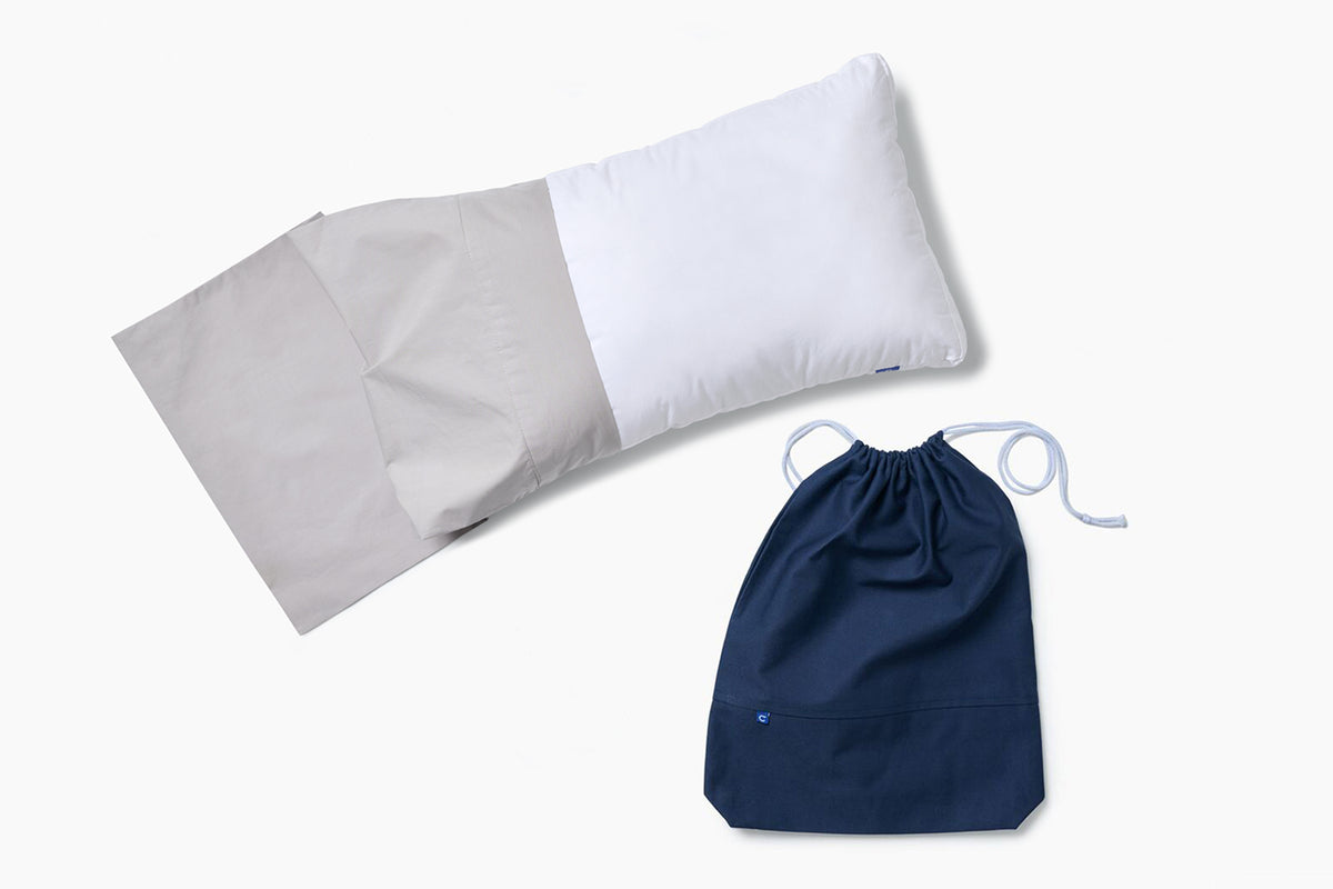 Casper Nap Pillow with a pillowcase and drawstring bag against a white background