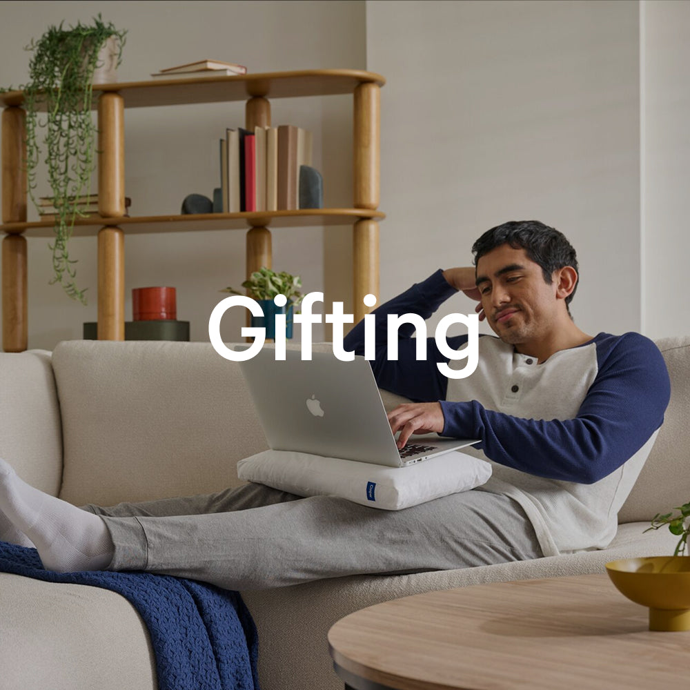 The word "gifting" appears on an image of a person using the Nap Pillow on his lap underneath a laptop.