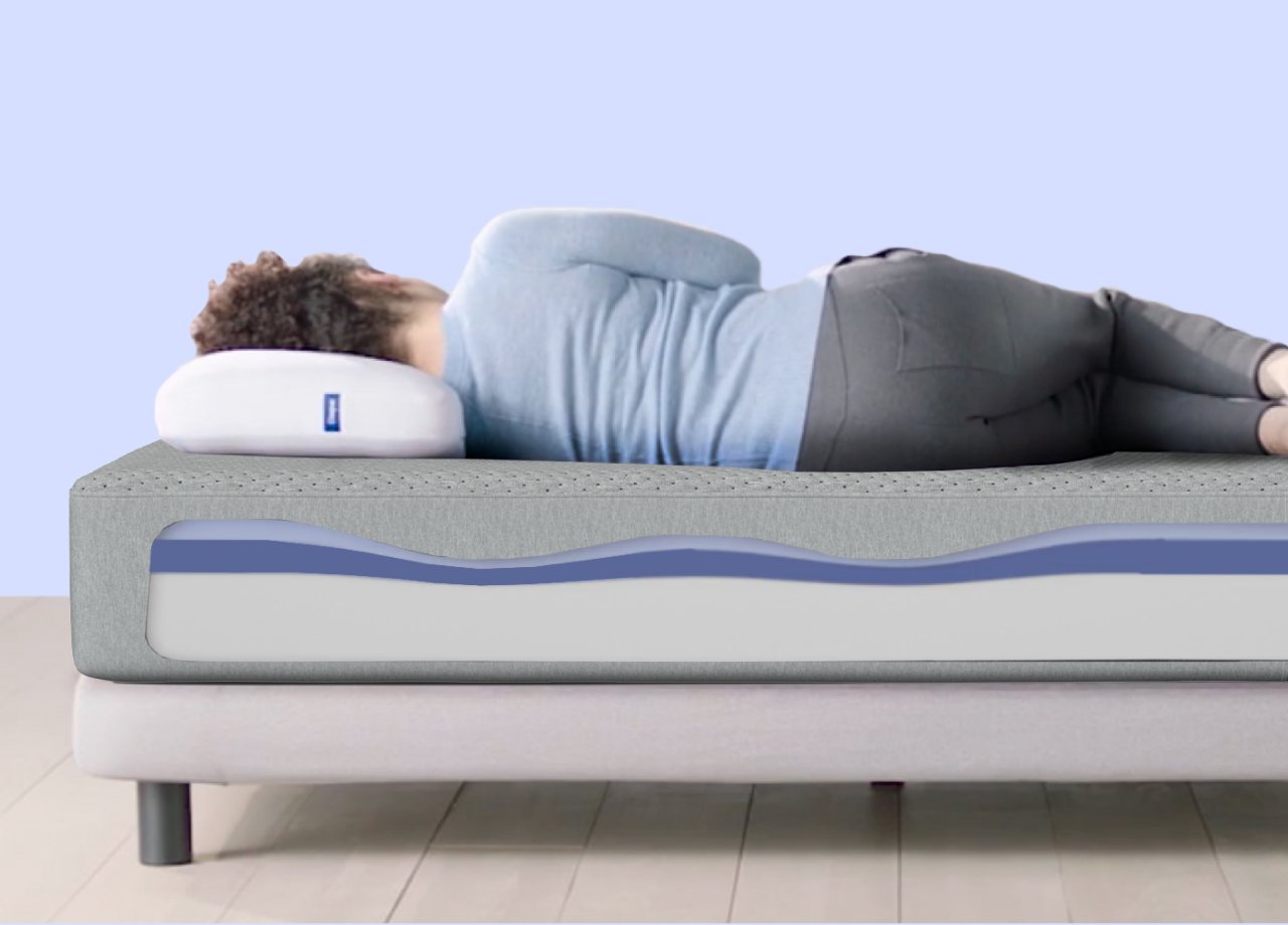 Side-view image of a person lying on their side on top of a mattress. A computer-generated graphic on the side of the mattress shows how it is designed to support our body evenly and keep our spine aligned, regardless of which parts of our body weigh more.