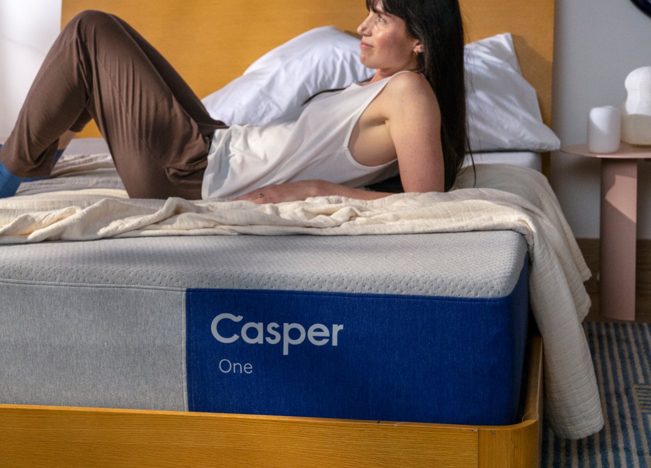 A woman lies back on her elbows on the Casper One mattress.