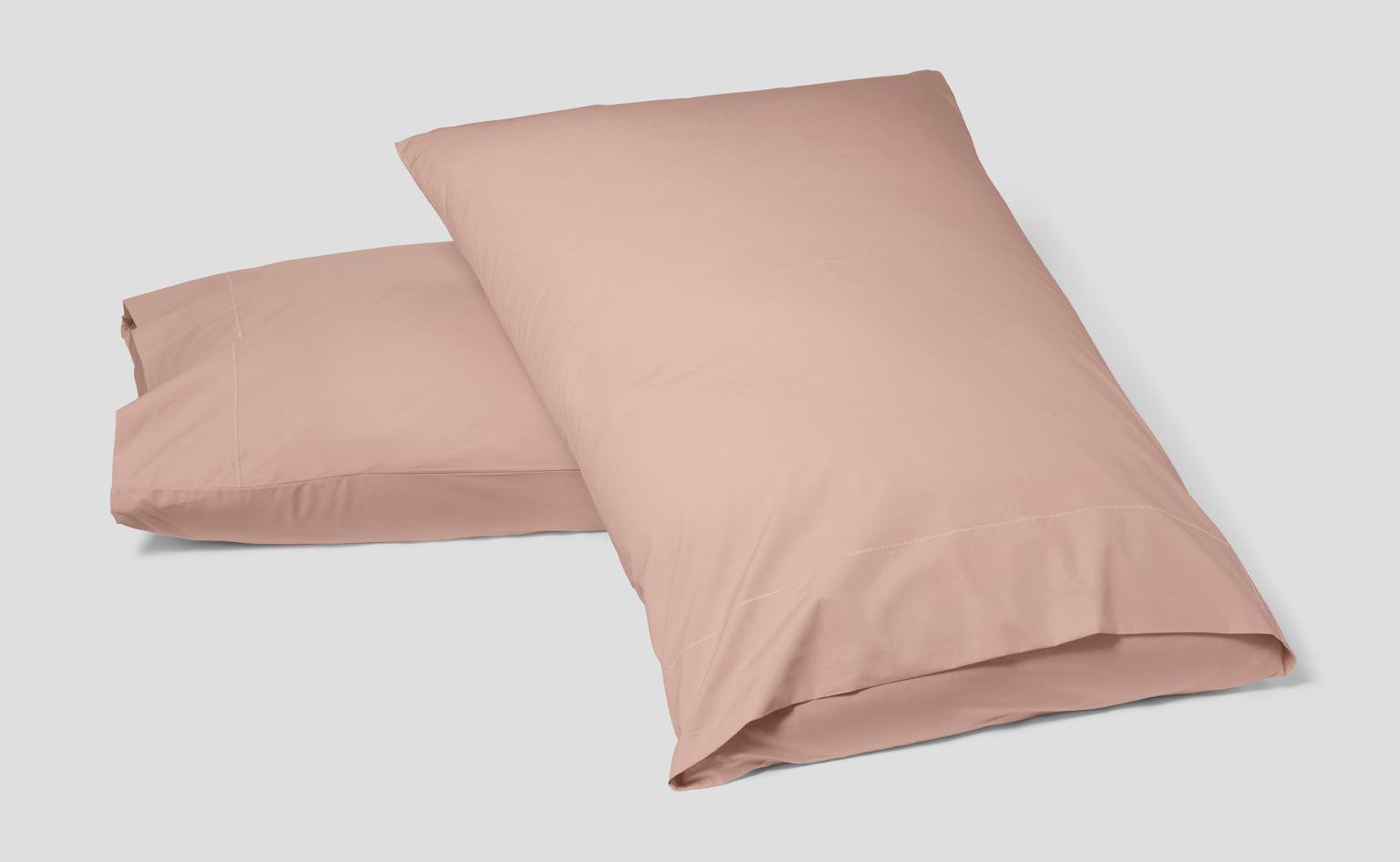 Image of two pillows in a Percale pillowcase, Dusty Rose colored.
