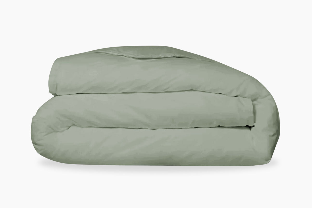 A folded, eucalyptus-green duvet cover against a white background