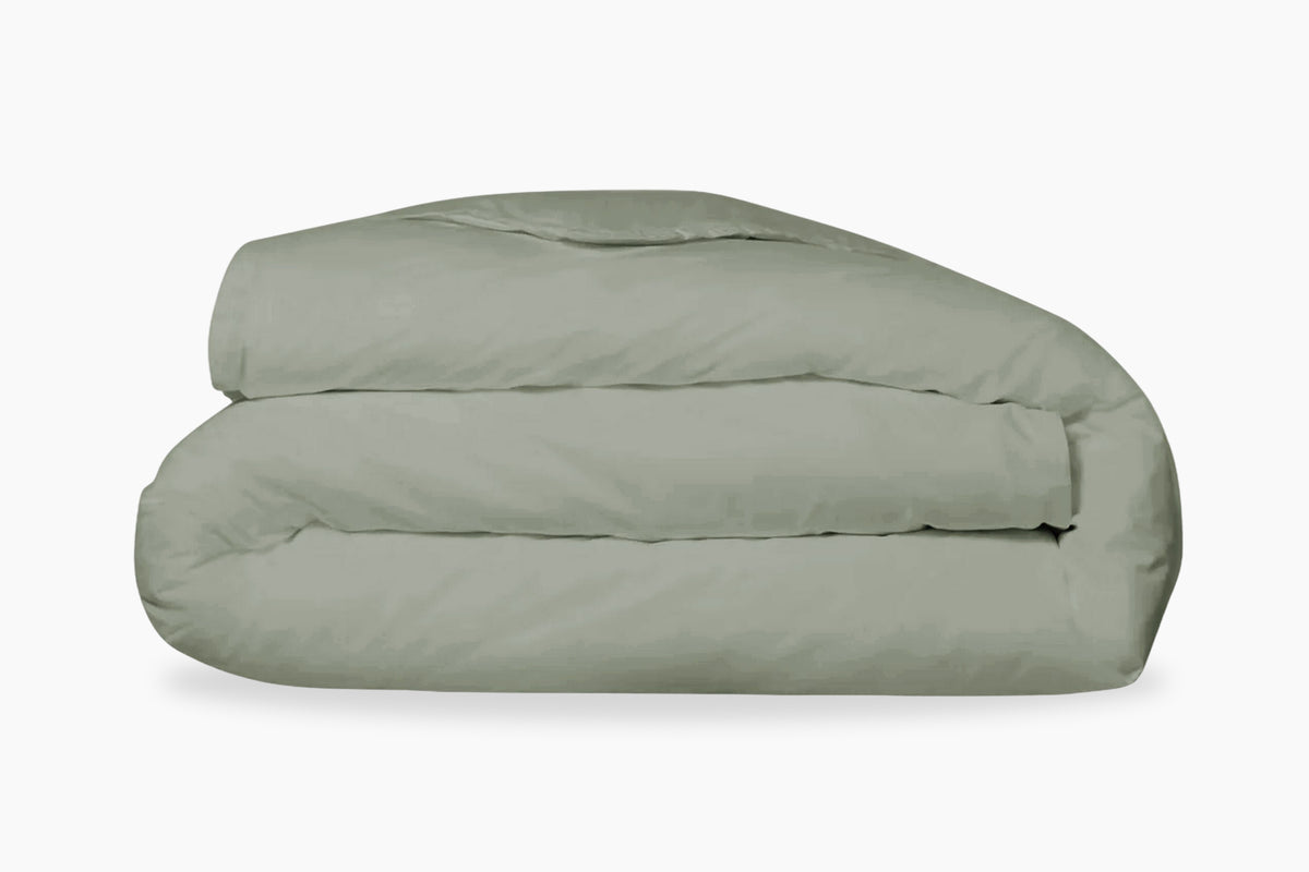 A folded, eucalyptus-green duvet cover against a white background