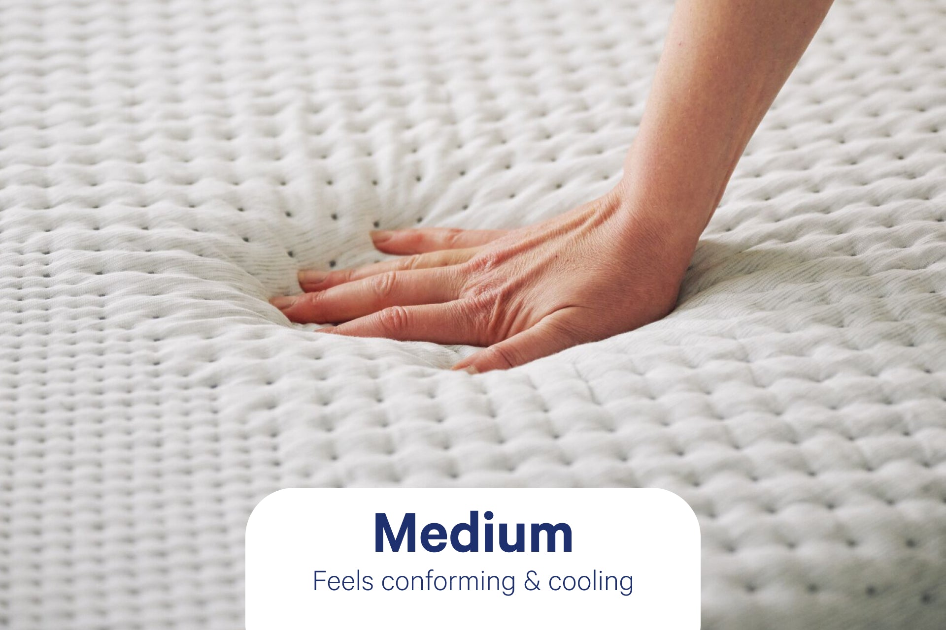 A person's hand pressing down to feel the Snow mattress. Text on the image indicates that its firmness level is Medium and feels conforming & cooling.