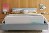 Casper's Snow Max mattress on a bed frame with pillows and a blanket folded on top.