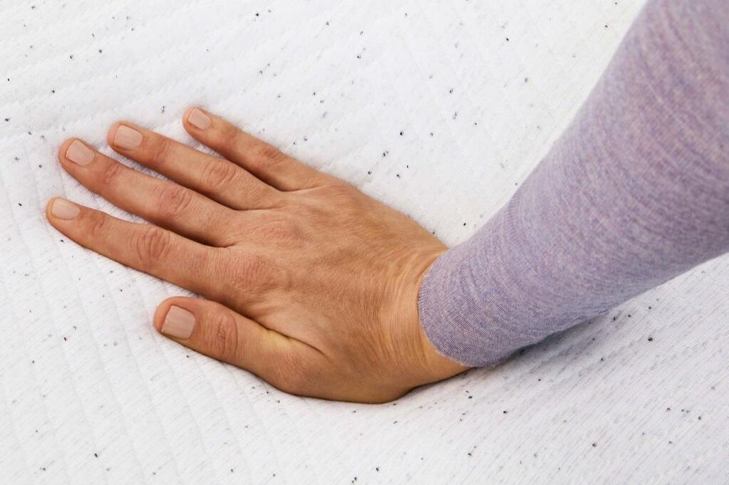 Close-up of a person's hand feeling the Casper Snow 2023 mattress