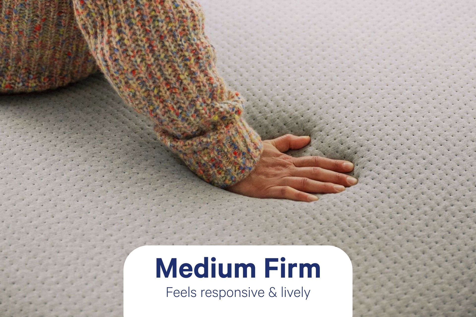 A person's hand presses down to feel The One mattress. It is medium firm and feels responsive and lively.