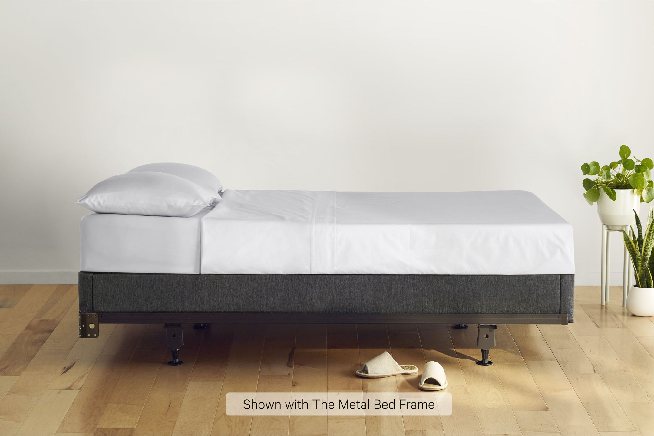 Side view of a made bed. The mattress is on a Foundation on top of a metal bed frame