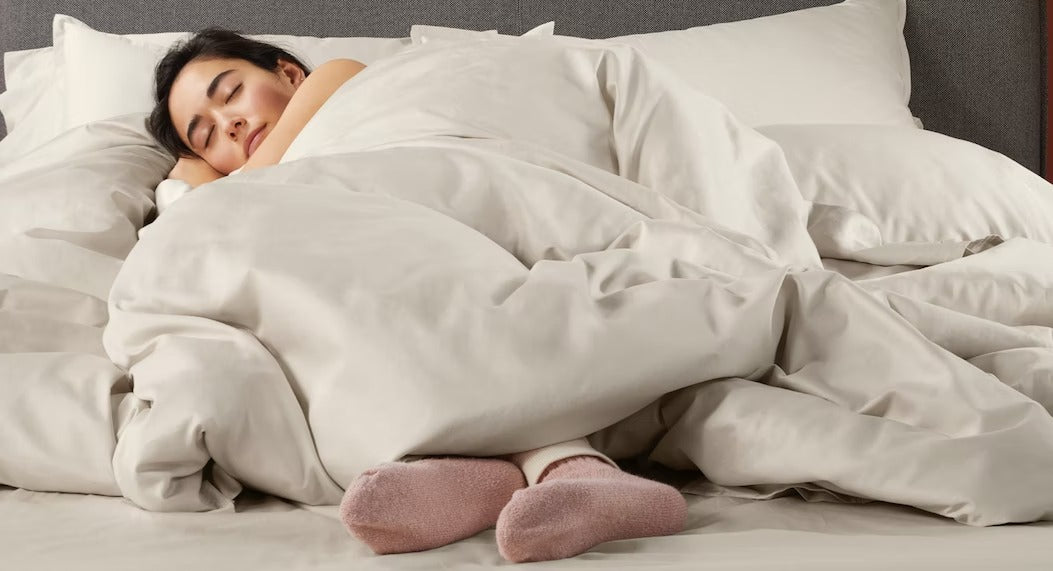 A woman sleeps cozily underneath her lightweight duvet.