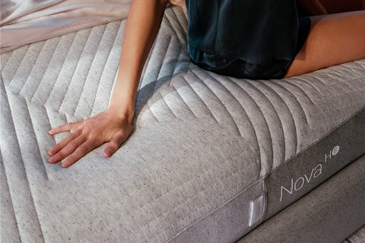 Young woman sitting on Nova hybrid mattress