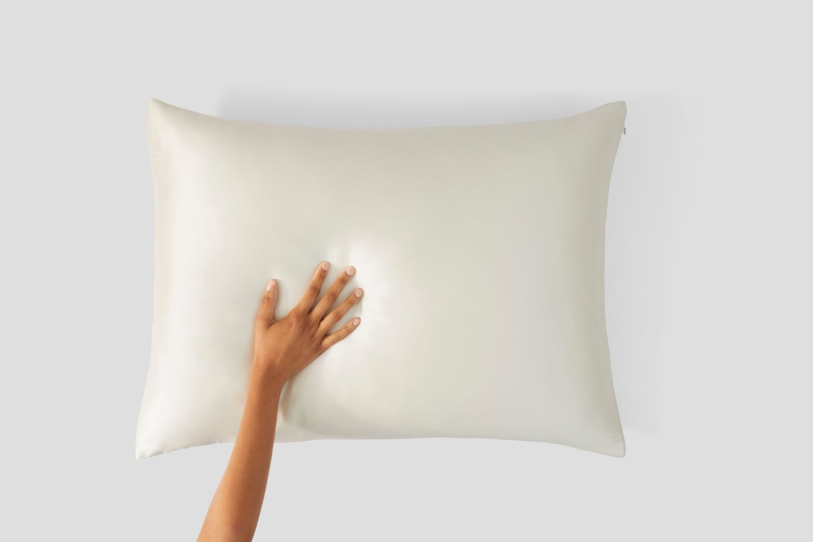 hand on silk pillowcase