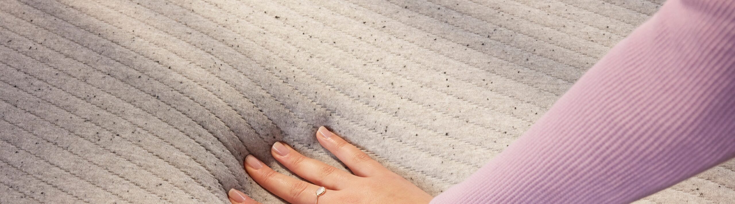 Woman's hand pushing down the memory foam mattress