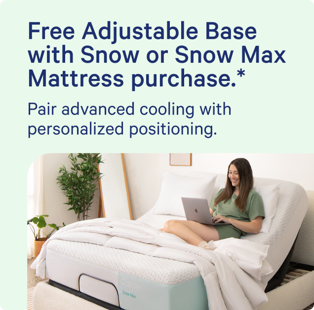 A promotional bed setup photo with a woman sitting on a mattress on an adjustable base and using a laptop. Large text at the top reads, 'Free Adjustable Base with Snow or Snow Max Mattress purchase. Pair advanced cooling with personalized positioning."