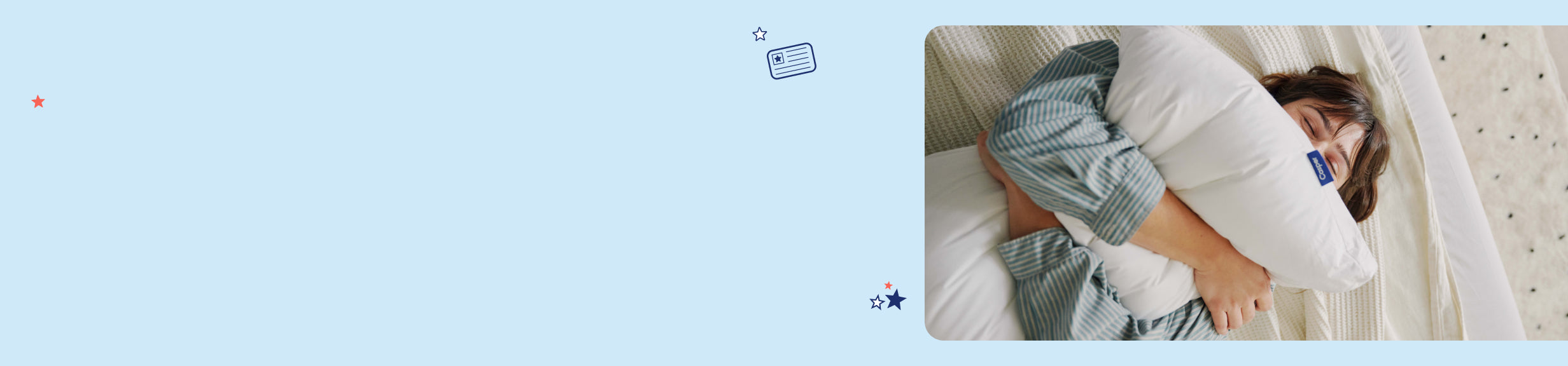 A person lying in bed, happily, squeezing a pillow.