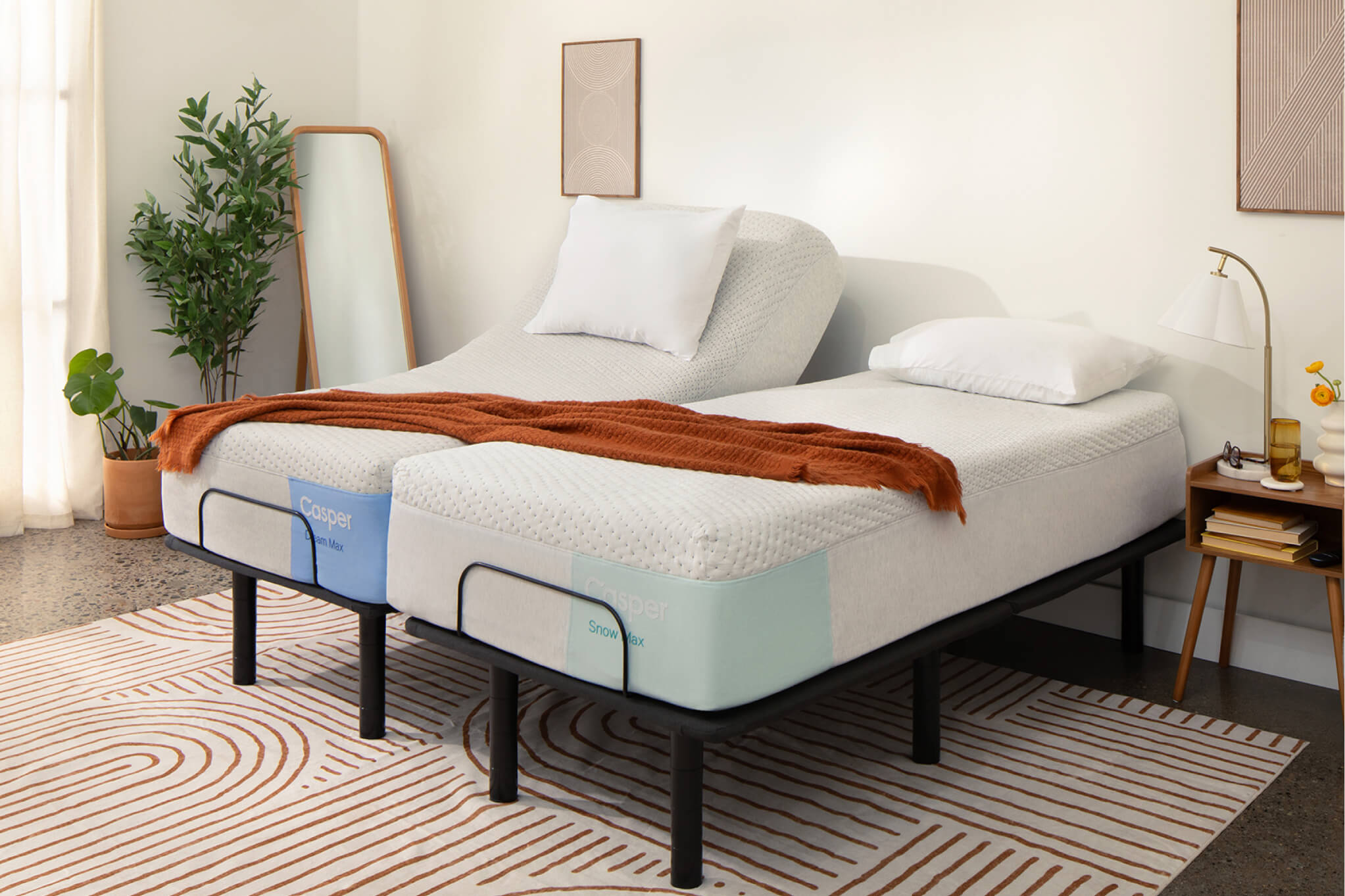 Image of a split king Adjustable Base with two Twin XL mattresses, one on each half of the bed frame. A blanket is laid out across both mattresses, demonstrating how two people can comfortably share a blanket and bed with the split king variety.