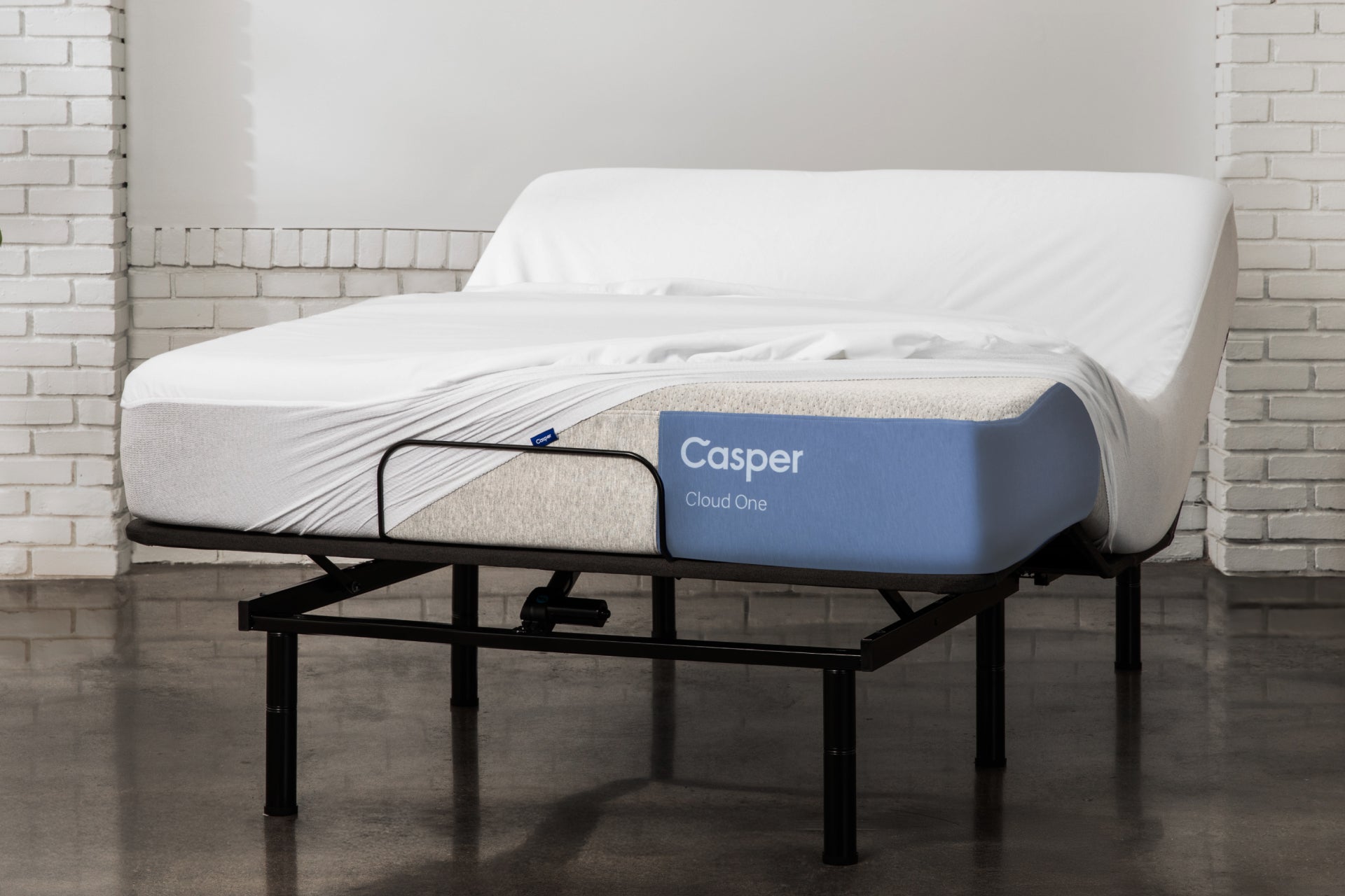 Casper's Cloud One mattress on an adjustable bed frame. A mattress protector is partially covering the mattress.