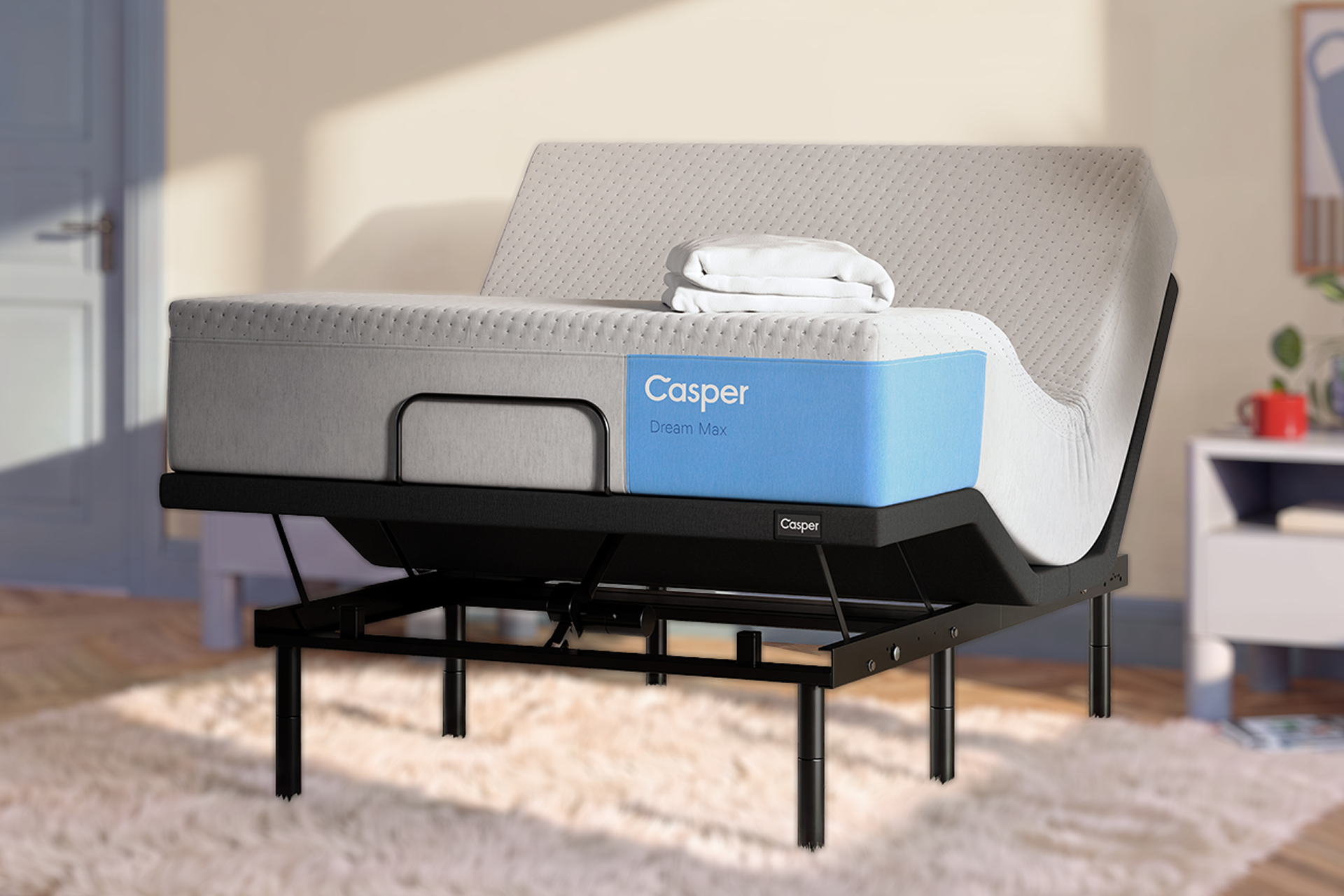 An adjustable bed frame with a Casper Dream Max mattress, shown in a styled bedroom setting with warm sunlight and a soft rug.