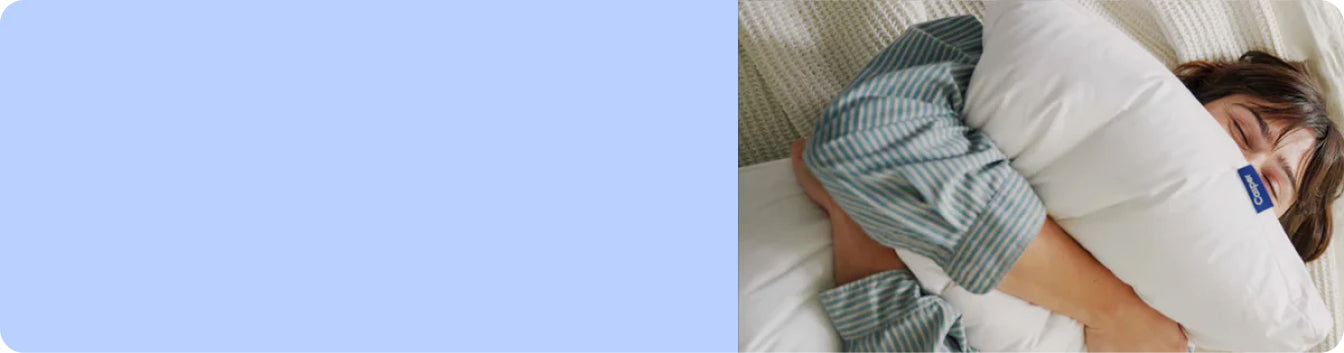 A person lying in bed squeezing a pillow