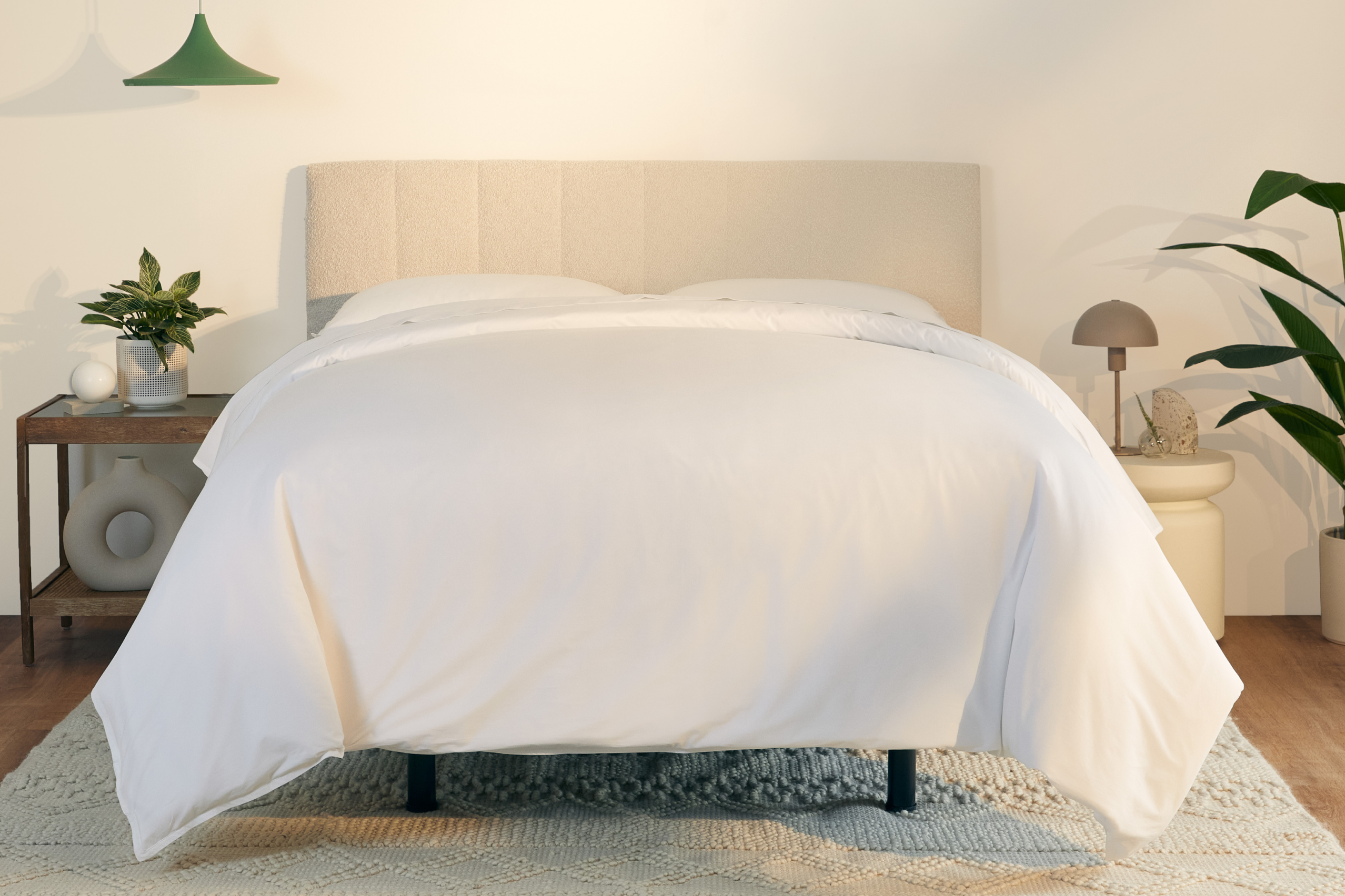 A fully made bed with a cream colored Bliss Attachable Headboard