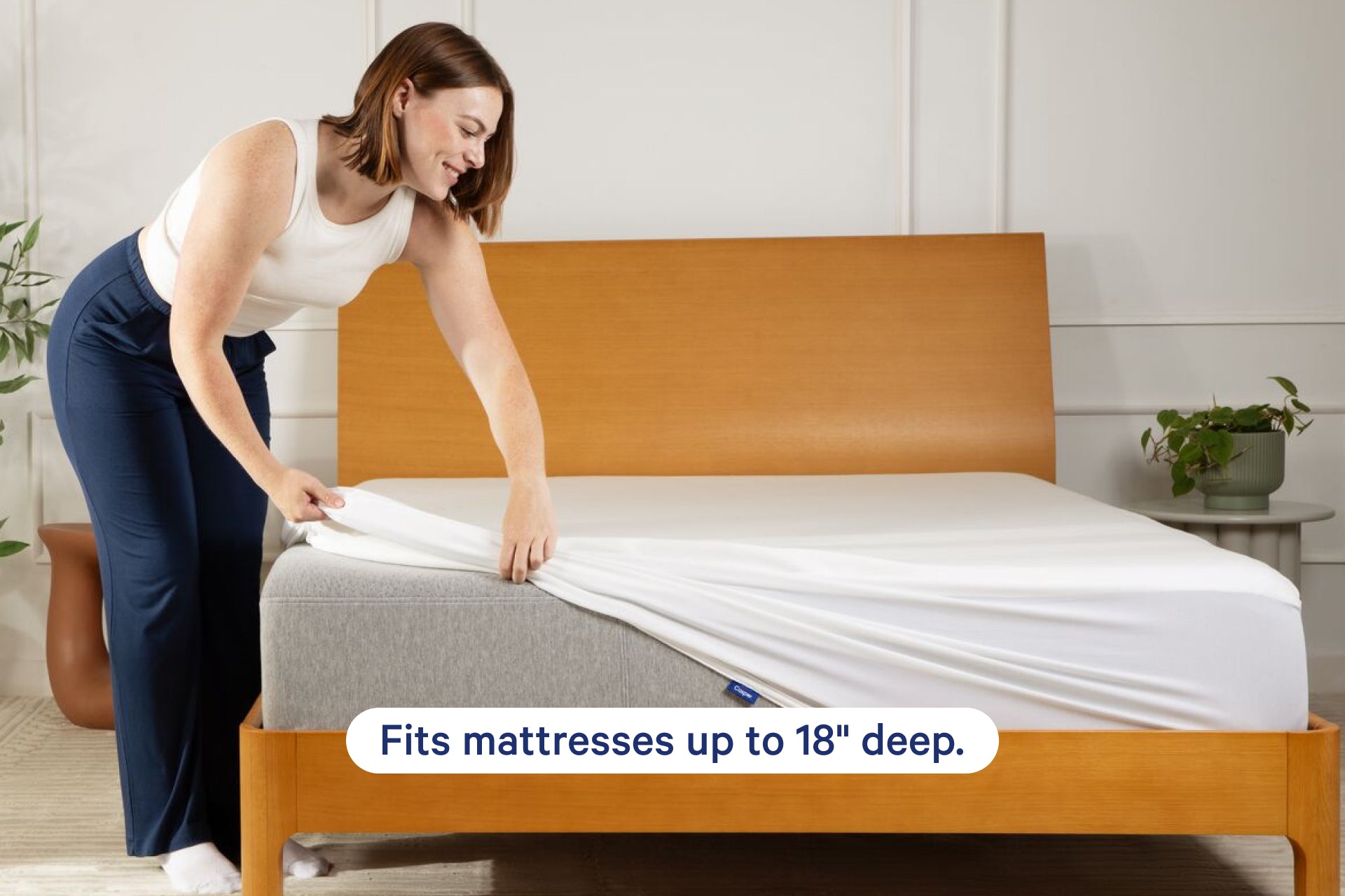 A woman installing the Breathable Mattress Protector on a mattress. Text on the image says "Fits mattresses up to 18" deep."