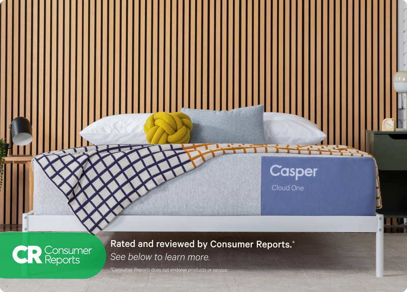 Casper's Cloud One mattress on a bed frame with pillows and a blanket folded on top. Text on the image says "Consumer Reports. Rated and reviewed by Consumer Reports. *Consumer Reports does not endorse products or services."