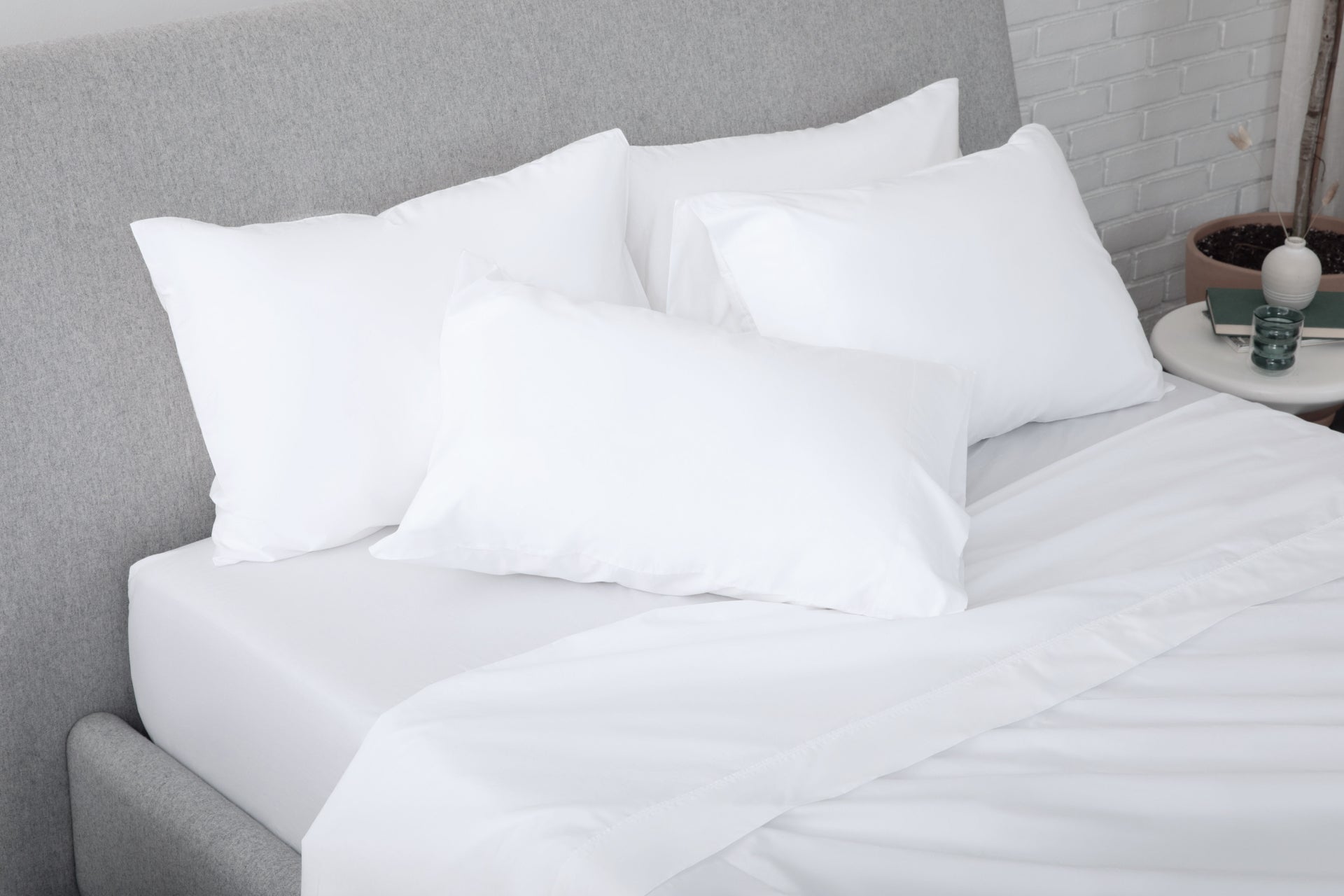 White pillows on a bed with a gray headboard