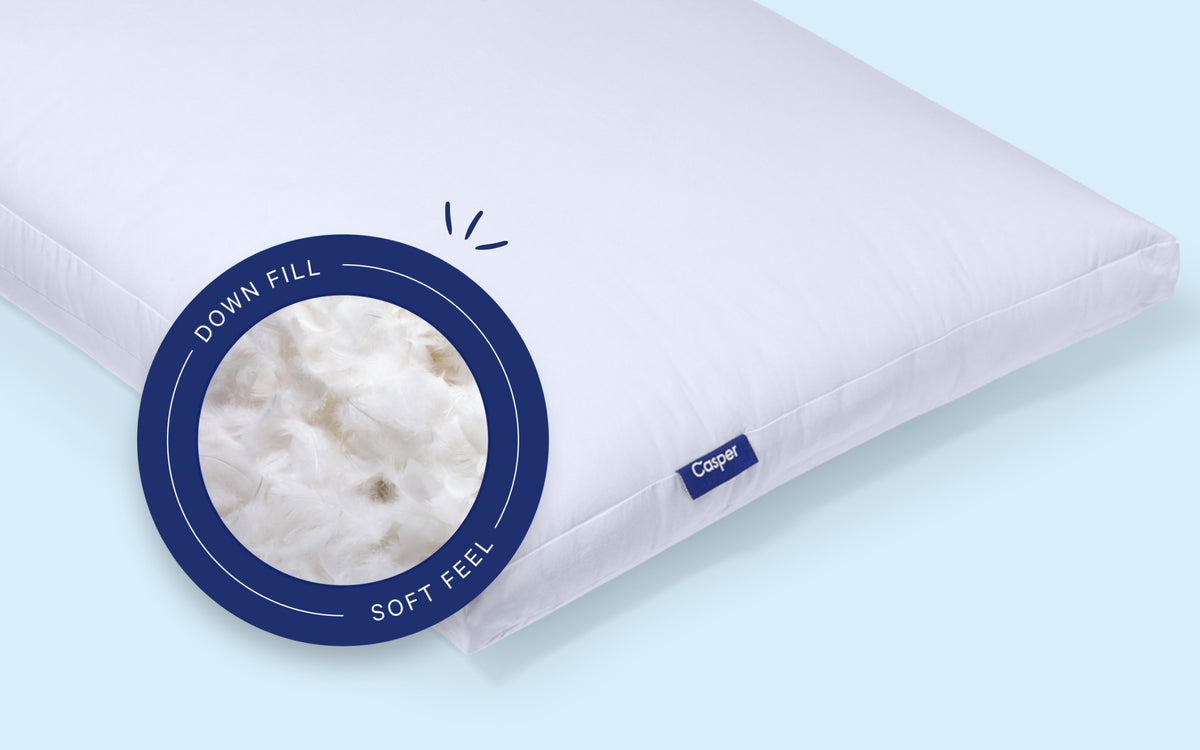 Casper's Down Pillow against a light blue background. A pill on the image indicates that it has down fill with a soft feel.