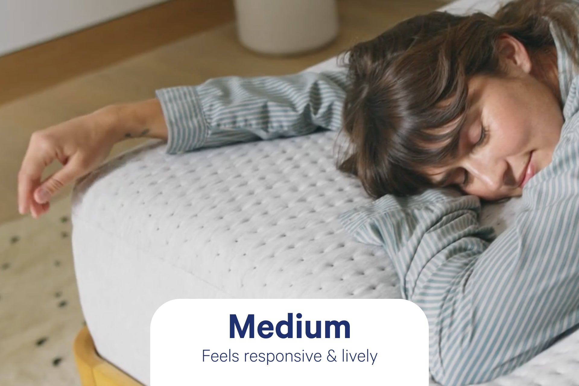 Close-up image of a person lying near the corner of her Casper Dream mattress. A badge on the image referring to the firmness level says "Medium. Feels responsive & lively."