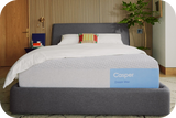 Casper's Dream Max mattress on a bed frame with pillows and a blanket folded on top.