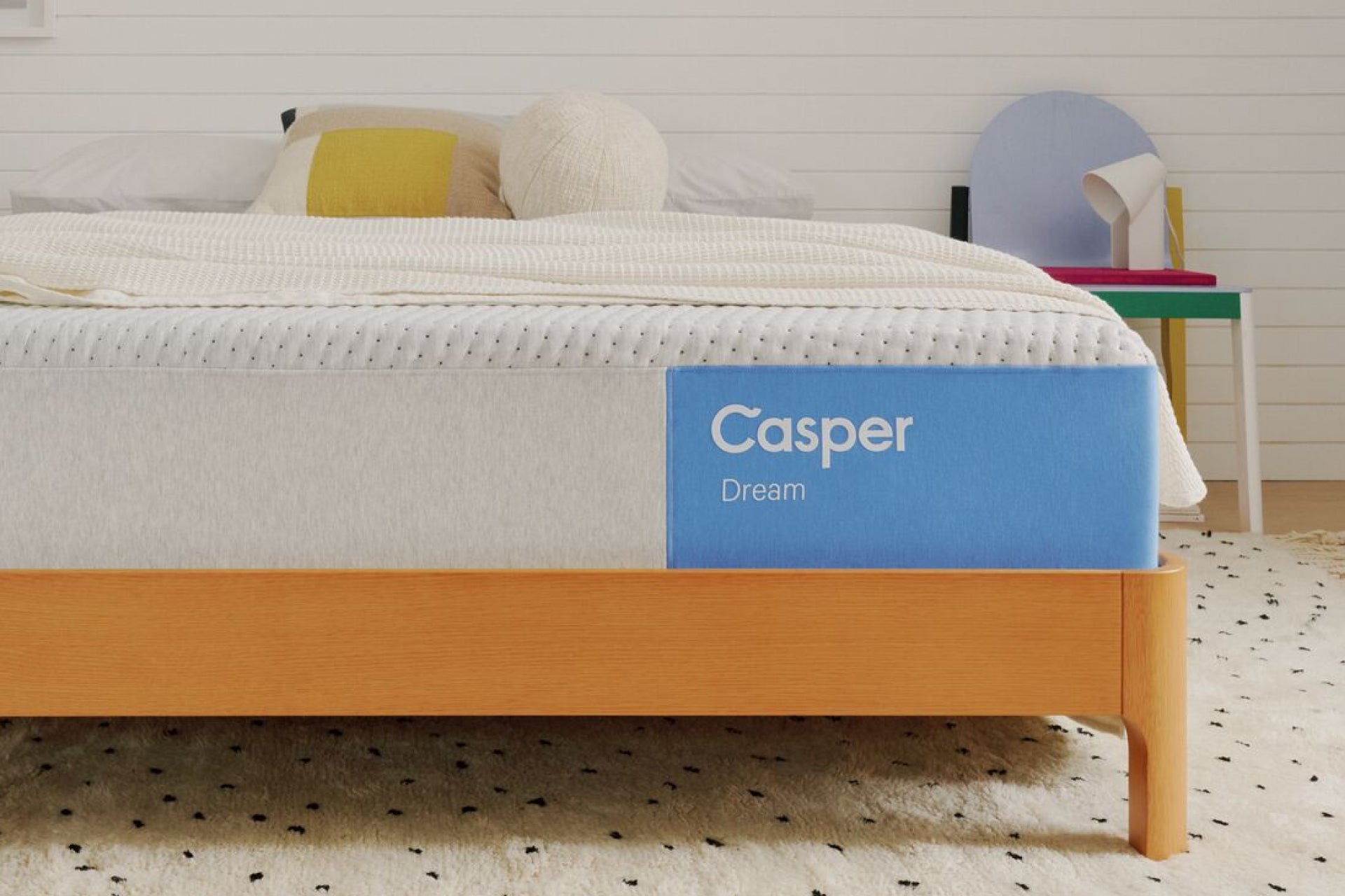 Casper's Dream mattress on a wooden bed frame with pillows and a blanket