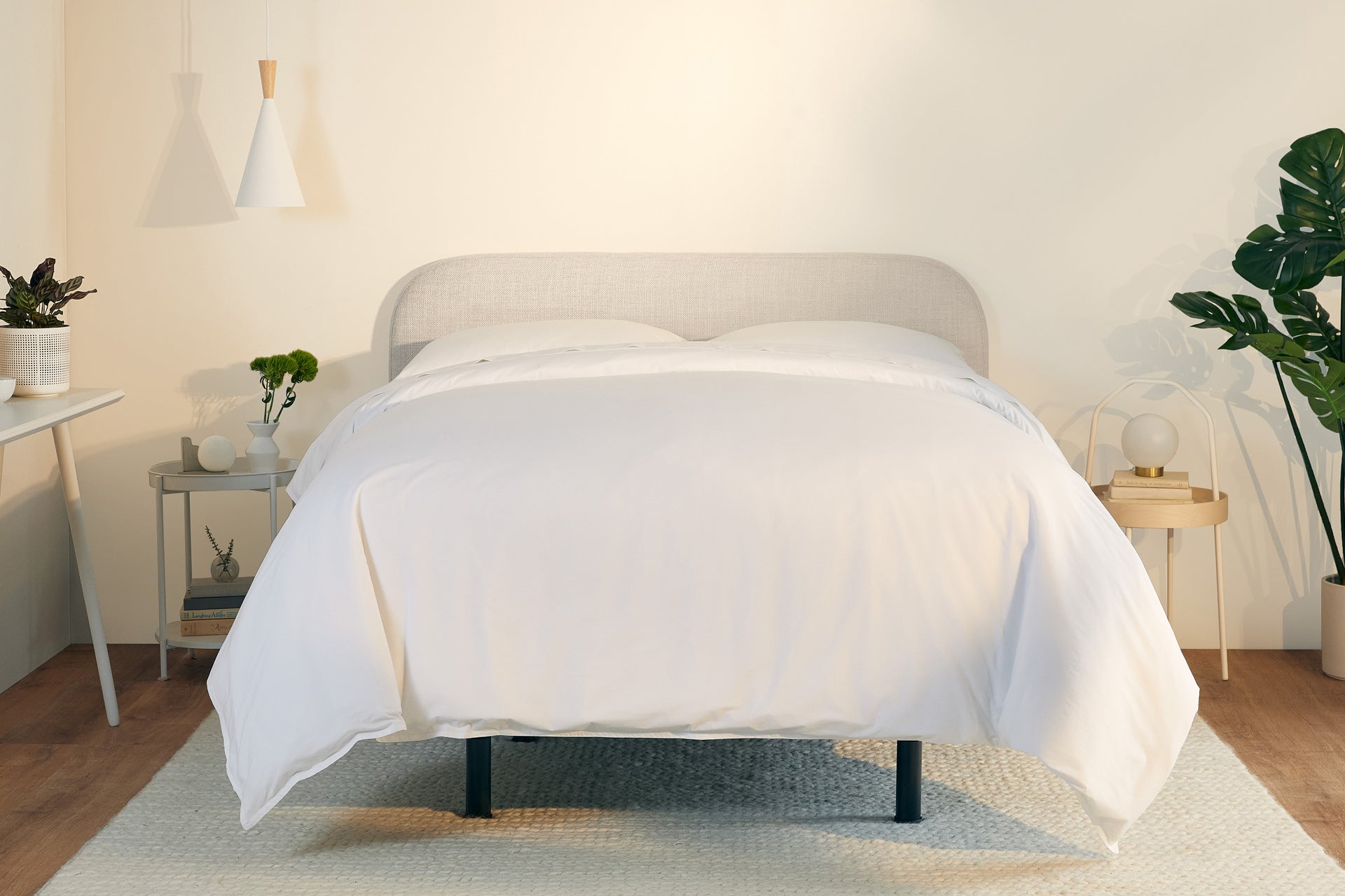 A fully made bed with a Drift Attachable Headboard, fog color. Front view.