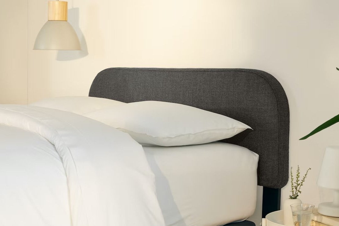 A fully made bed with a Drift Attachable Headboard, Slate color. Side view.