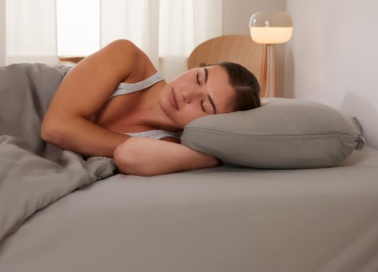 Close-up image of a person lying on their side in bed. The Essential Topper offers added comfort for your best night's rest.